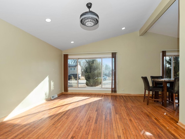 interior space with lofted ceiling with beams, baseboards, visible vents, and wood-type flooring