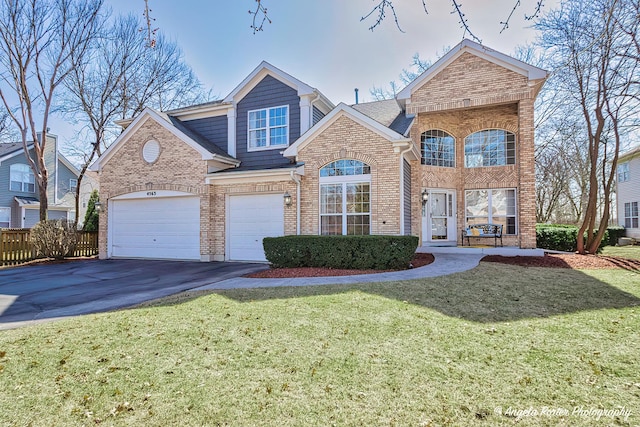 traditional-style home with brick siding, a garage, driveway, and a front yard