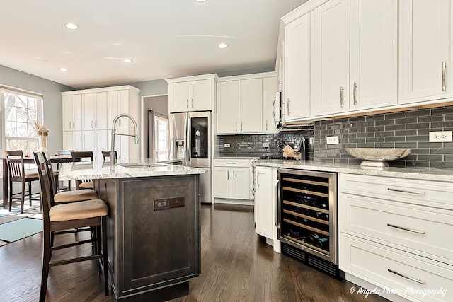 kitchen featuring a sink, wine cooler, appliances with stainless steel finishes, and white cabinets