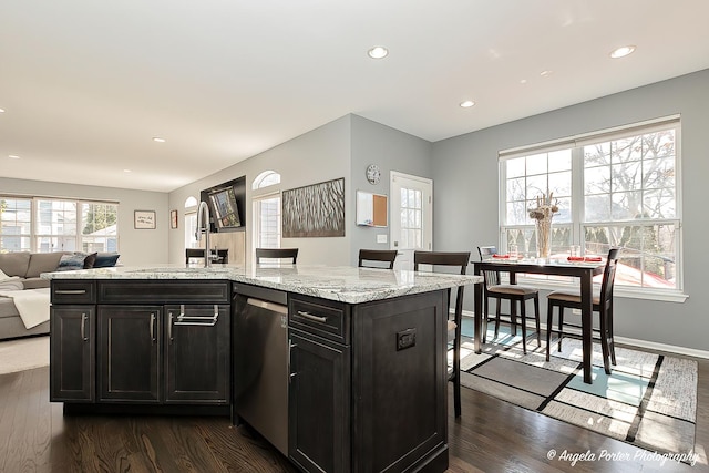 kitchen with open floor plan, a healthy amount of sunlight, dishwasher, and a sink