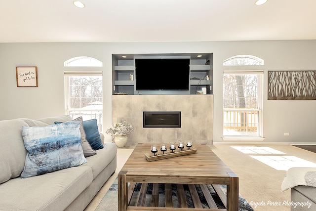 living area featuring baseboards, built in features, carpet floors, recessed lighting, and a fireplace