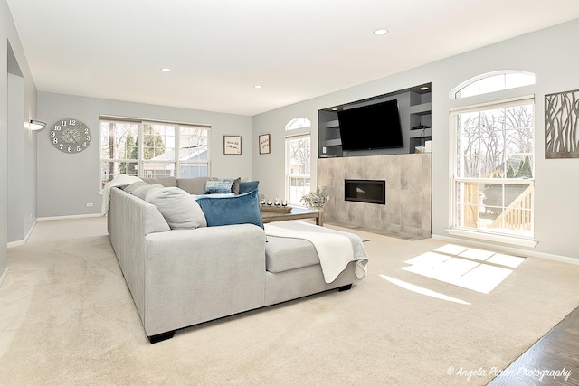 living room featuring recessed lighting, carpet flooring, baseboards, and a tiled fireplace