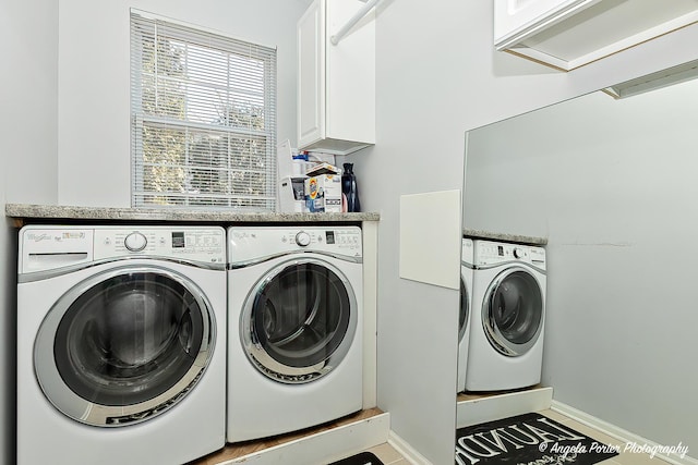 laundry room featuring baseboards, cabinet space, and independent washer and dryer