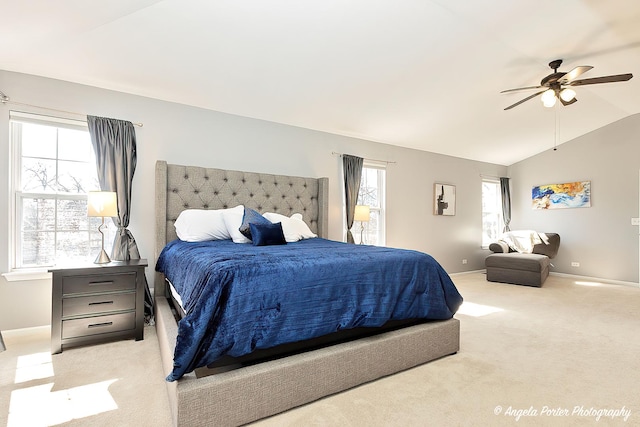 carpeted bedroom featuring vaulted ceiling, multiple windows, baseboards, and ceiling fan