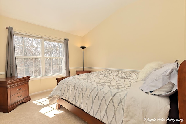 bedroom with vaulted ceiling and light colored carpet