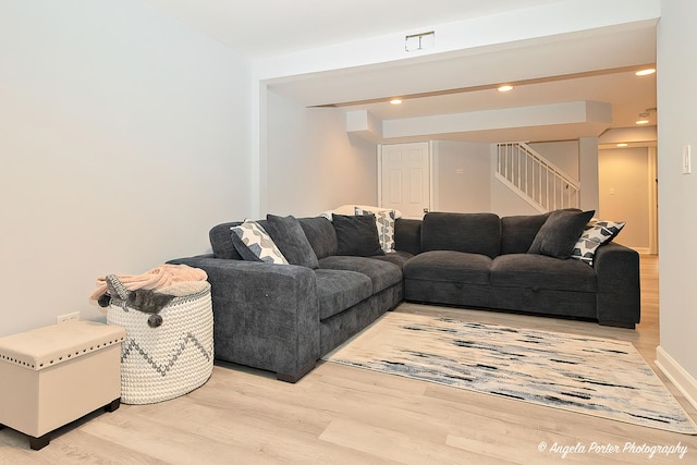 living room featuring stairs, recessed lighting, light wood-type flooring, and baseboards