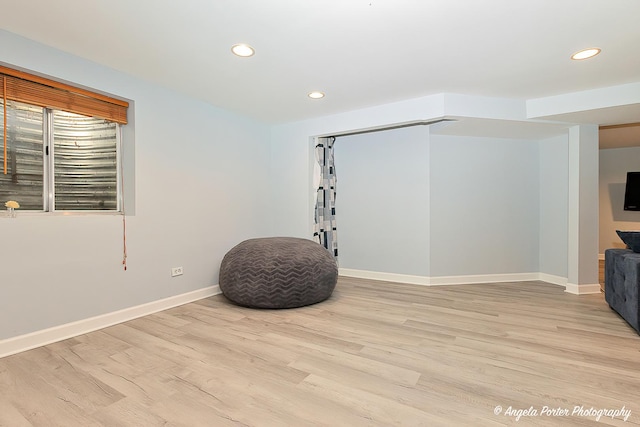 workout area featuring recessed lighting, light wood-type flooring, and baseboards