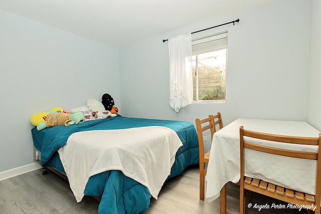 bedroom with baseboards and wood finished floors