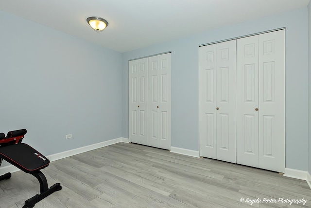 exercise area with light wood-type flooring and baseboards