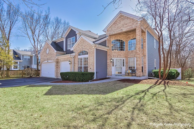 traditional-style house featuring aphalt driveway, a front lawn, brick siding, and fence