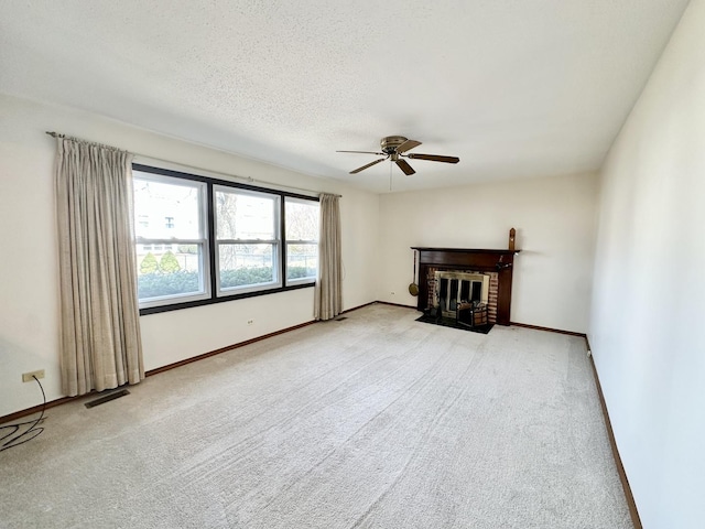 unfurnished living room with baseboards, a fireplace, visible vents, and light carpet