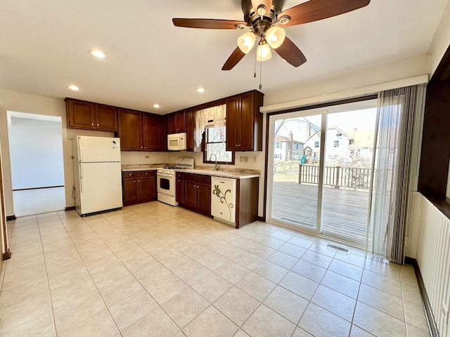 kitchen with visible vents, a sink, recessed lighting, white appliances, and light countertops