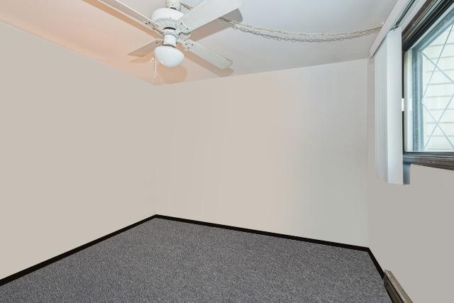 carpeted empty room with baseboards and ceiling fan