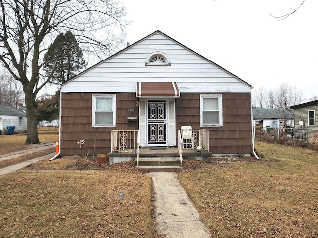 bungalow-style home with a front yard and fence