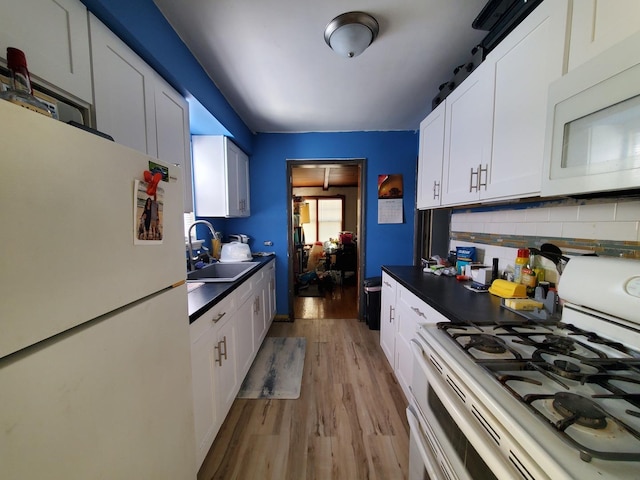 kitchen with tasteful backsplash, white cabinets, white appliances, and a sink