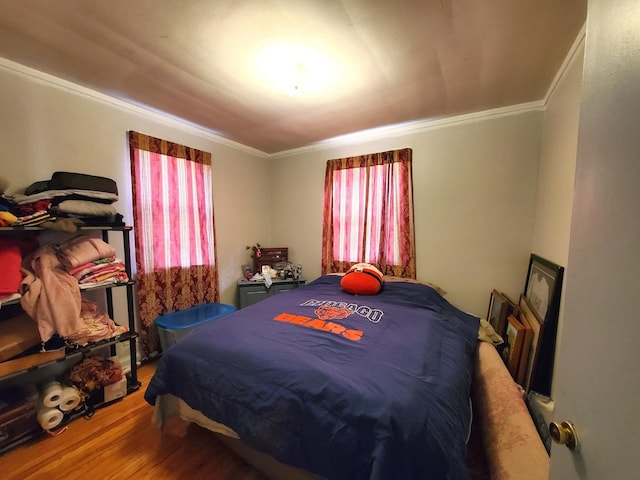 bedroom featuring wood finished floors and ornamental molding