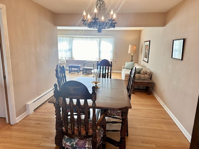 dining area with an inviting chandelier, baseboards, light wood finished floors, and a baseboard radiator