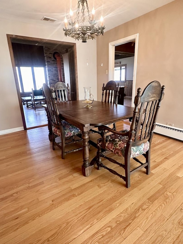 dining area with visible vents, baseboards, a notable chandelier, and light wood finished floors