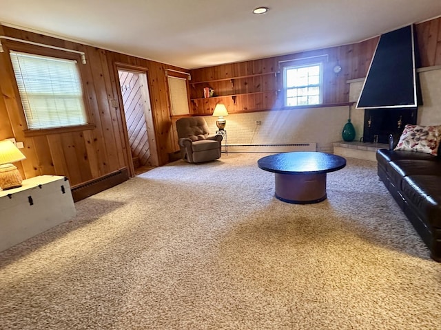 living room with a baseboard heating unit, carpet, wood walls, and a baseboard radiator