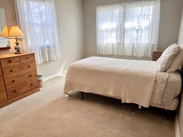 carpeted bedroom with multiple windows and baseboards