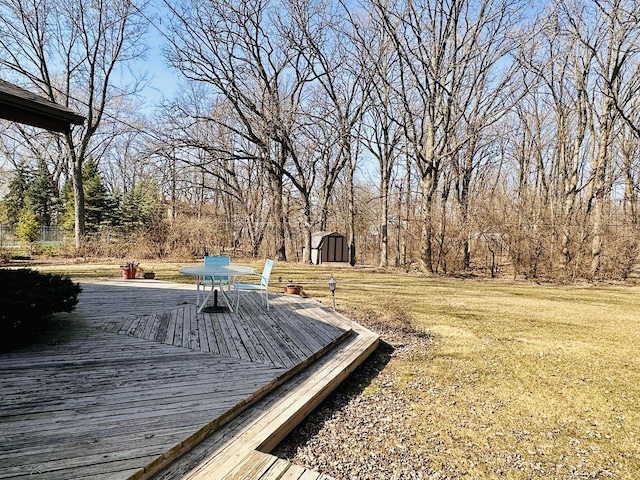 wooden terrace with an outbuilding, a lawn, and a shed