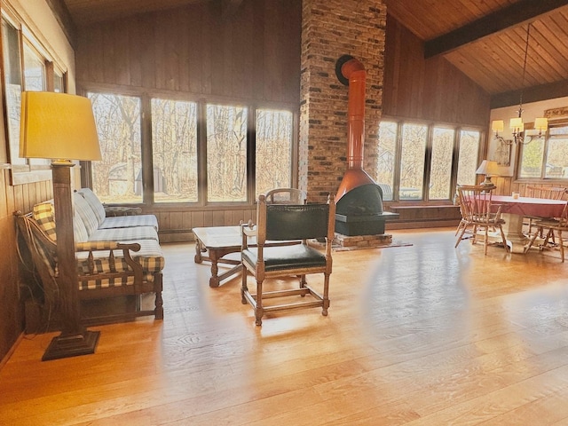 interior space with wooden ceiling, a wood stove, and lofted ceiling with beams