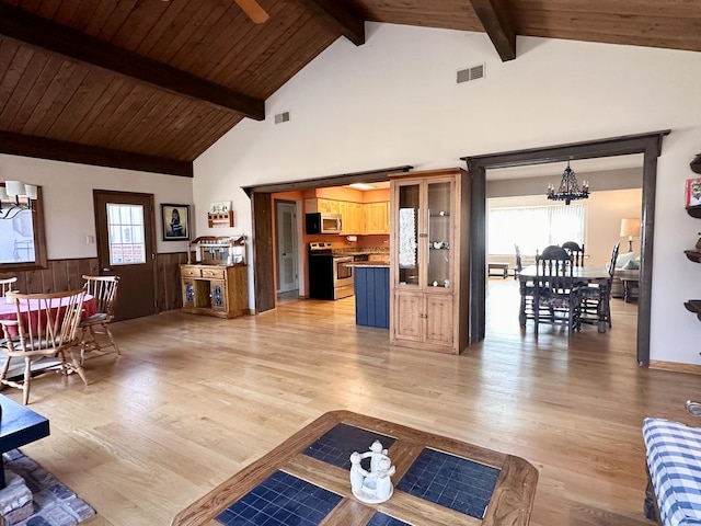 living room featuring a chandelier, visible vents, light wood-style flooring, and beamed ceiling