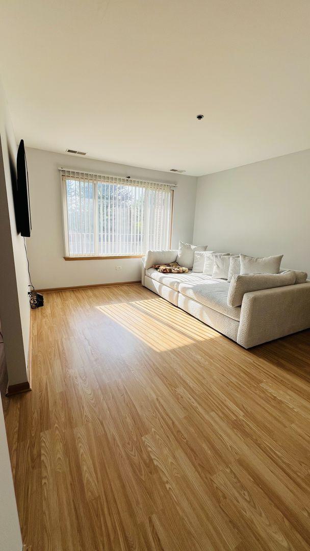 unfurnished living room with visible vents, baseboards, and wood finished floors