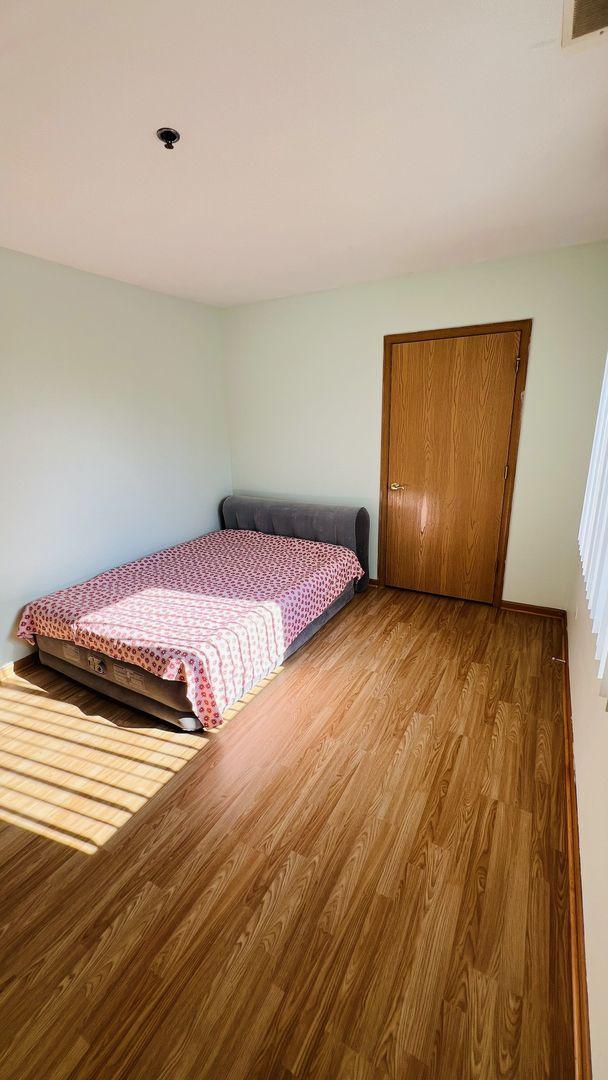 bedroom with a closet, visible vents, and wood finished floors