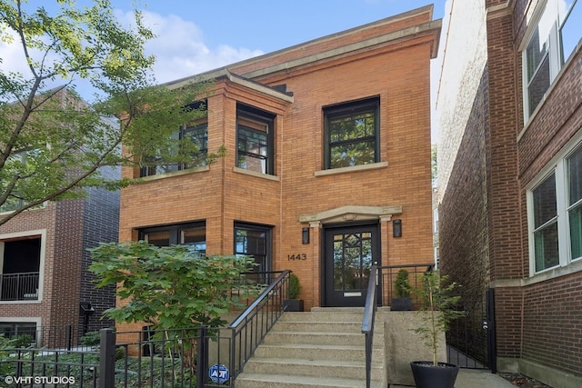 view of front of house featuring fence and brick siding