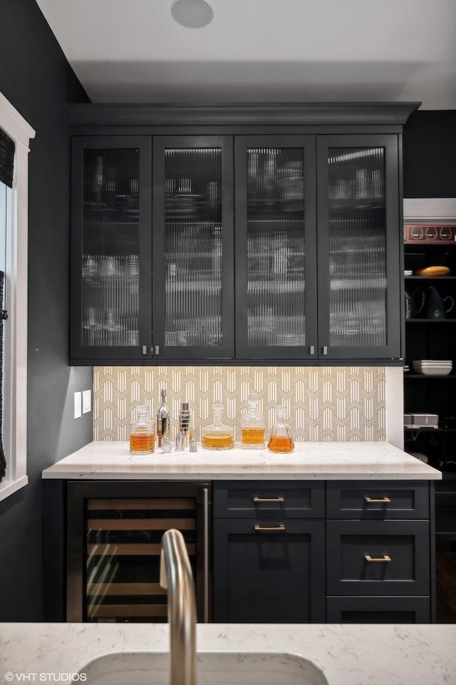 bar with decorative backsplash, wine cooler, and a dry bar