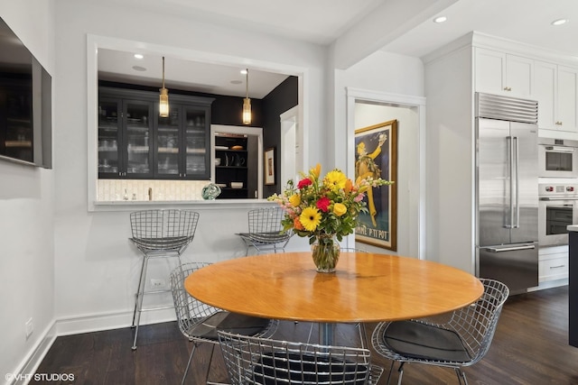 dining area with dark wood-style floors, recessed lighting, and baseboards