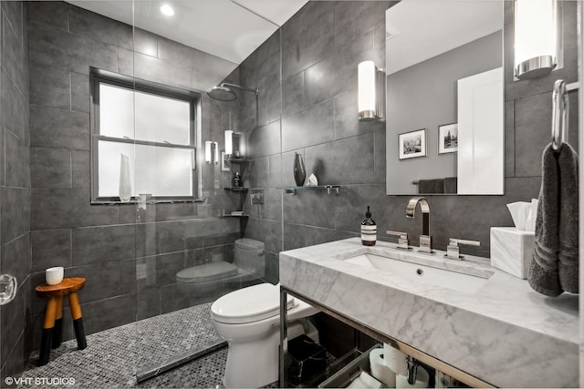 full bathroom with vanity, walk in shower, tile walls, toilet, and backsplash