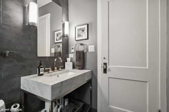 bathroom with vanity and tile walls