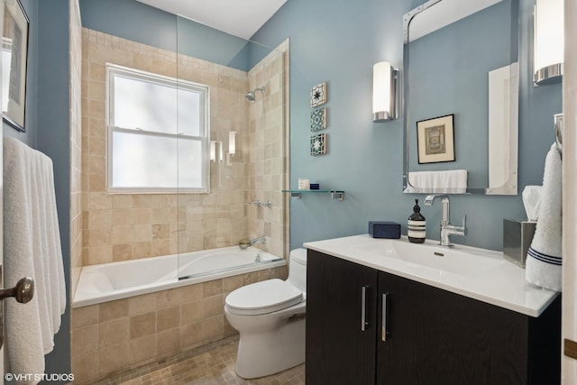 bathroom with toilet, vanity, and tiled shower / bath