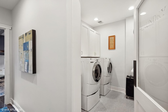 washroom with visible vents, baseboards, washer and clothes dryer, recessed lighting, and cabinet space