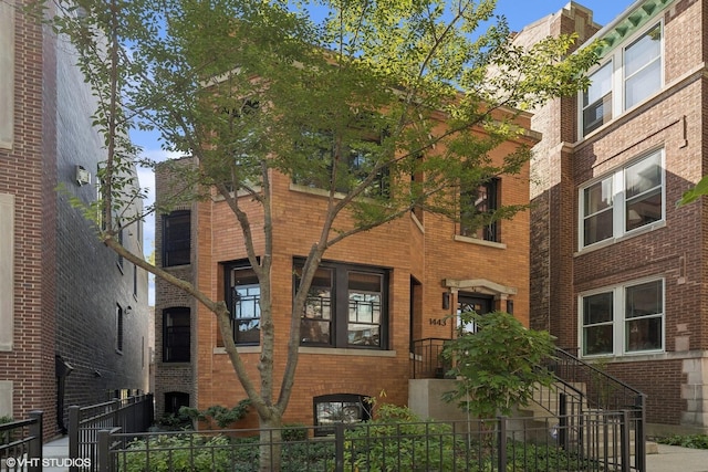 view of front facade with brick siding and a fenced front yard