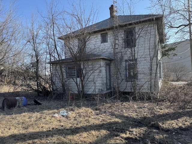 rear view of property featuring a chimney