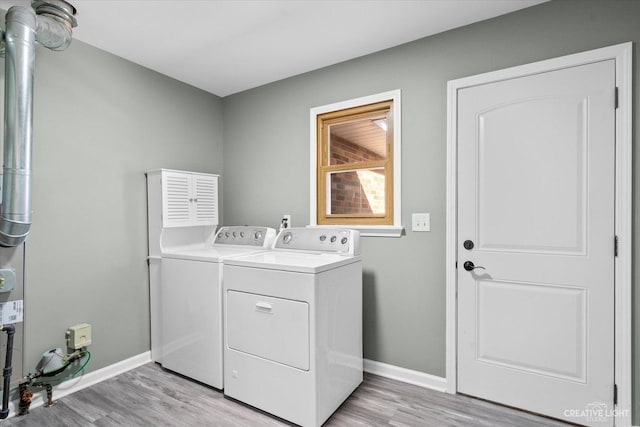 laundry room featuring washing machine and clothes dryer, laundry area, light wood-style floors, and baseboards