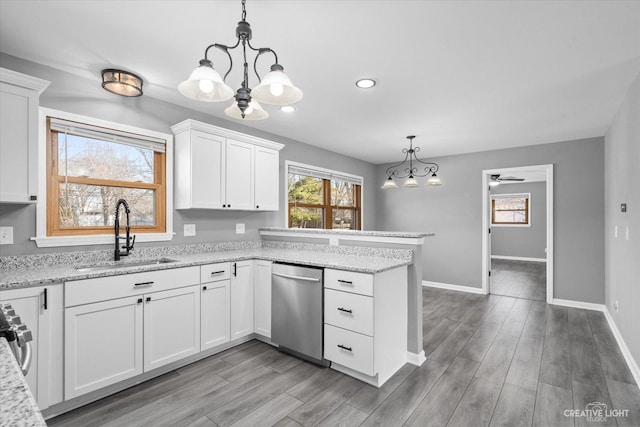 kitchen with a sink, light wood-style flooring, a peninsula, white cabinetry, and stainless steel dishwasher