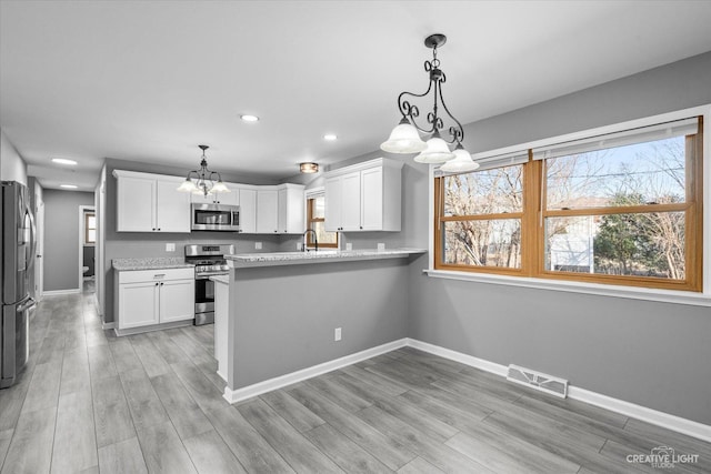 kitchen featuring white cabinetry, visible vents, and stainless steel appliances