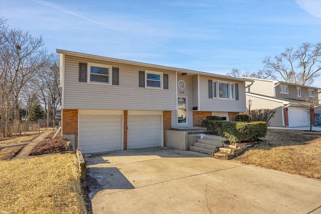 bi-level home featuring brick siding, driveway, and a garage