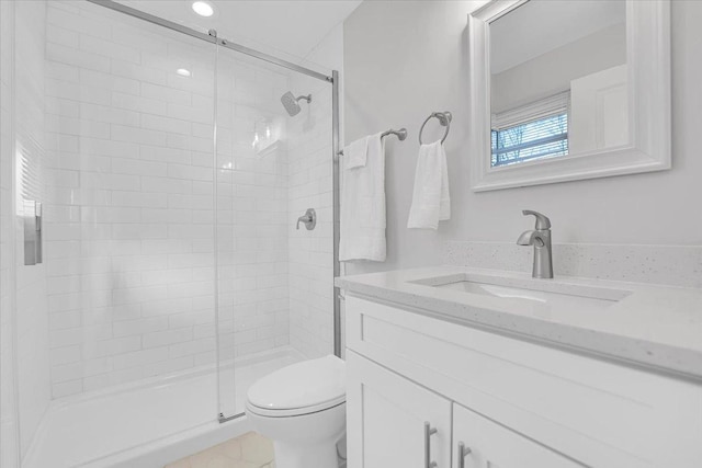 bathroom featuring toilet, a stall shower, and vanity