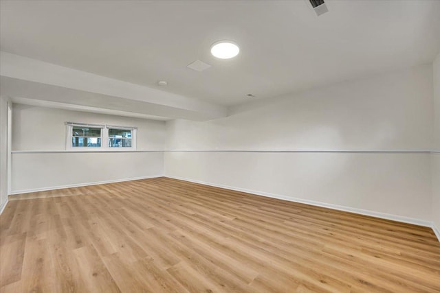 empty room with visible vents, light wood-style floors, and baseboards