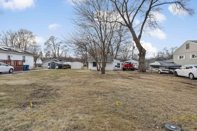 view of yard featuring an outdoor structure, a storage unit, and a residential view