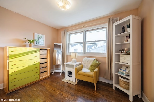 living area with dark wood-type flooring and baseboards