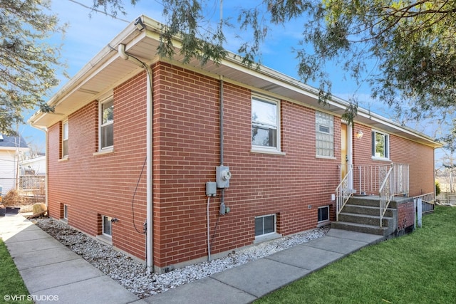 view of home's exterior with a yard and brick siding