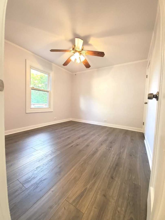 unfurnished room with dark wood-type flooring, baseboards, and ornamental molding