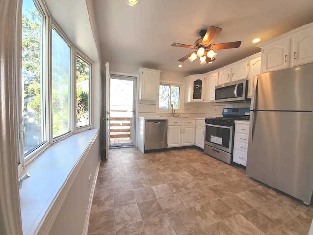 kitchen with stainless steel appliances, light countertops, and white cabinetry