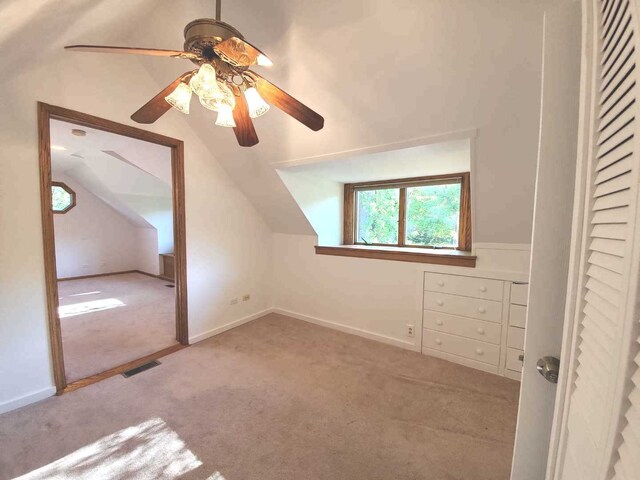 additional living space featuring visible vents, baseboards, vaulted ceiling, carpet floors, and a ceiling fan